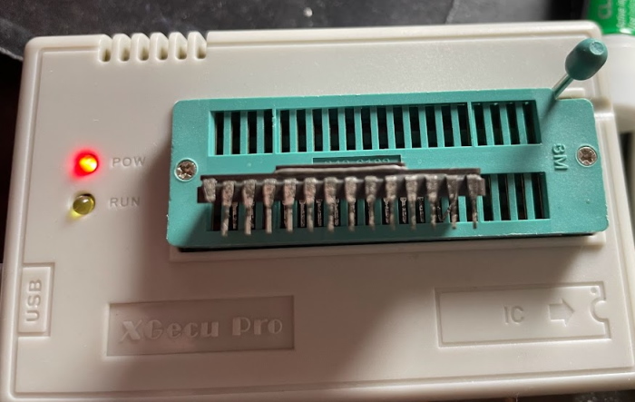 A side view of a chip sitting on a TL866 programmer