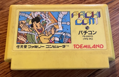 Pachi-com cartridge, a yellow Famicom cartridge with an image of a pachinko enthusiast at his machine, balls flying everywhere