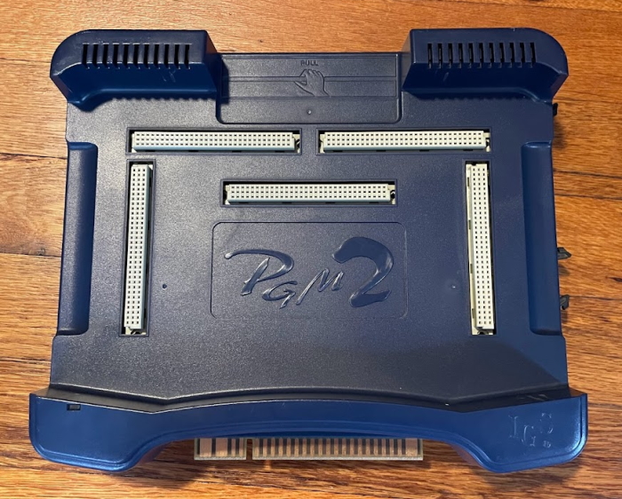 A PGM2 with its cartridge removed, revealing five connectors and an embossed PGM2 logo