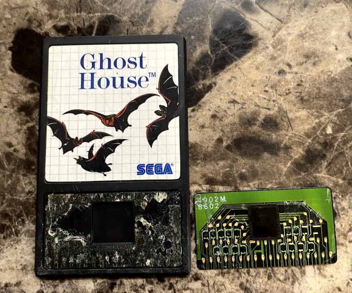 The Ghost House Sega Card internals. A small green circuitboard is the size of the lower half