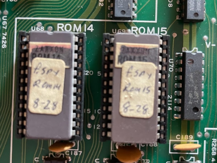 Two EPROMs. They have stickers with a fandwritten 'f.spy' logo, but a printed sticker they cover up says ZAXXON, crossed out with marker