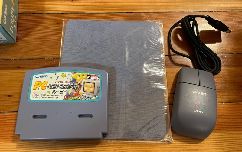 The PC Collection for the Casio Loopy cartridge, alongside a mouse and a mousepad