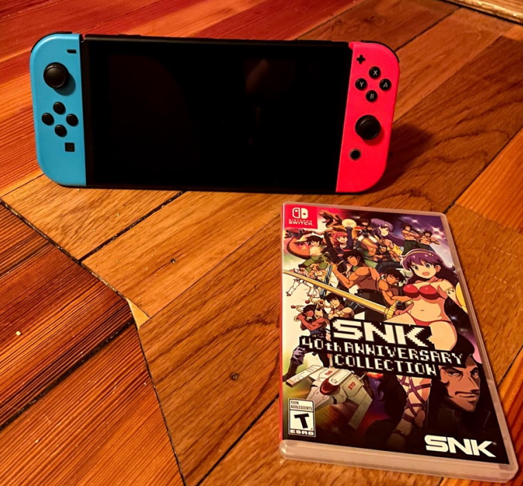 A Nintendo Switch with a boxed copy of SNK 40th Anniversary collection
