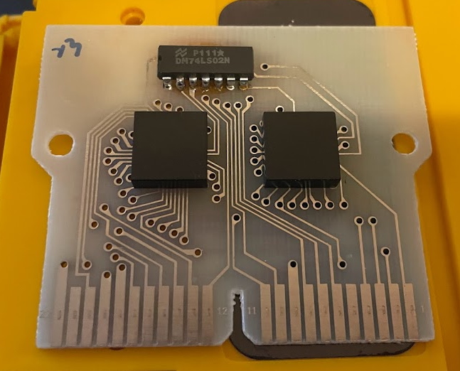 A Videocart circuitboard. Two unlabeled square chips sit below a 74LS02N