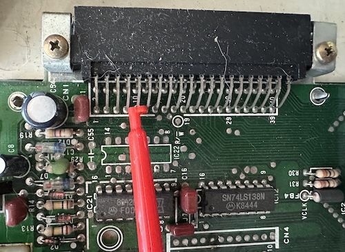 A Color Computer Cartridge, or CoCoCa for short... A red clip lead on pin 9 of the CoCo cartridge slot