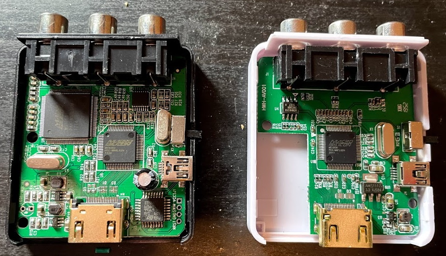 The insides of two plastic 'MINI' branded upscalers; the black one has a larger circuitboard