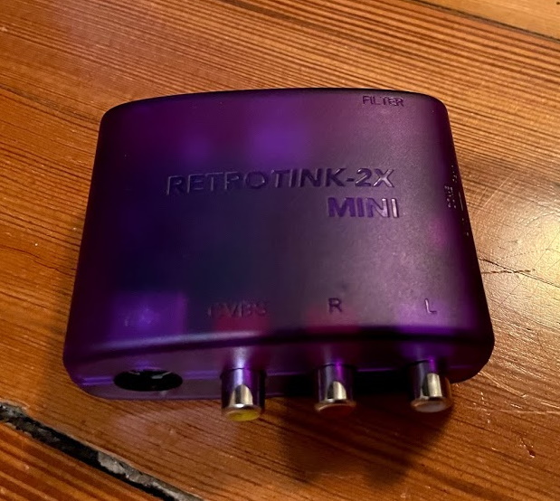 A purple RetroTINK-2X Mini