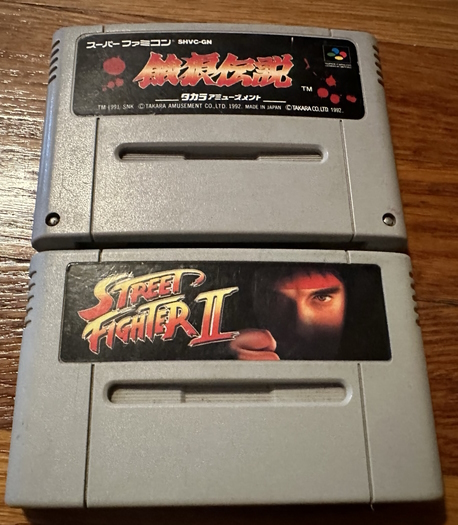 A Super Famicom Street Fighter 2 game with another game plujgged into it