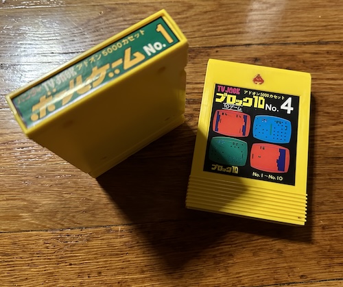 Two yellow TV Jack 5000 cartridges, one standing on its edge and one lying down