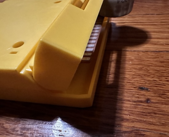 The yellow cartridge hinge, and the slot that pulls it open