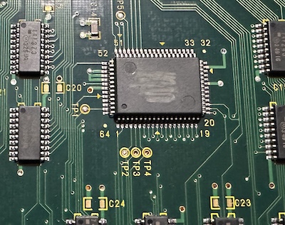 how rude Zoomed in on a 64-pin surface-mount chip with its label scratched off