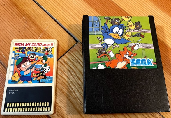 A Sega Card (Teddy Boy Blues) next to a larger SG-1000 cartridge (Flicky)