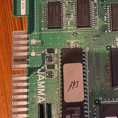 A cropped circuitboard close up. A JAMMA connector is labeled, but one pin, pin 5, does not have a pad. It has a small SNK logo