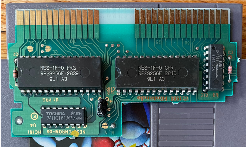 The CNROM board above. The chips are clearly labeled now. On the top row, NES-1F-0 PRG, NES-1F-0 CHR, and a small Nintendo-labeled IC. On the bottom, a 74HC161 branded Toshiba.