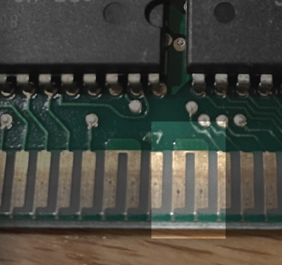 Two pins are highlighted on an edge connector. They are linked.