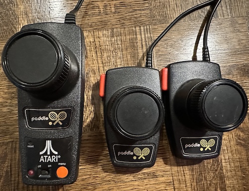 the bigger Atari Paddle next to the real Atari Paddles, which are smaller and in a pair