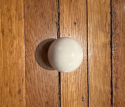 A white ball on a hardwood floor