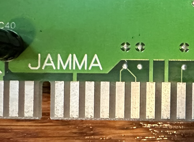 Mini Vaders circuitboard, zoomed in on a JAMMA edge connector. Two pins are connected to a via