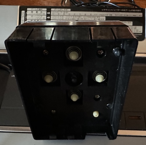 Joystick underneath, showing fingers that press buttons